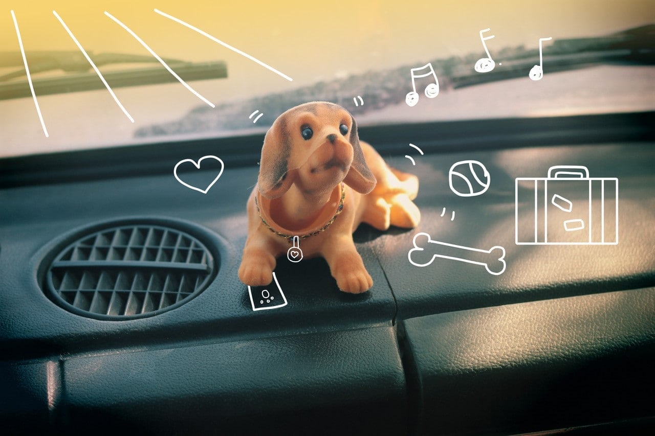 Nodding toy dog on a car dashboard. Pet insurance from MiPet Cover.